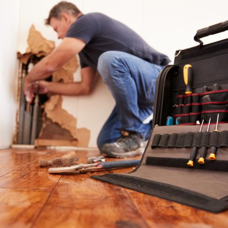 Middle,Aged,Man,Repairing,Burst,Pipe,plumbing,,Focus,On,Foreground